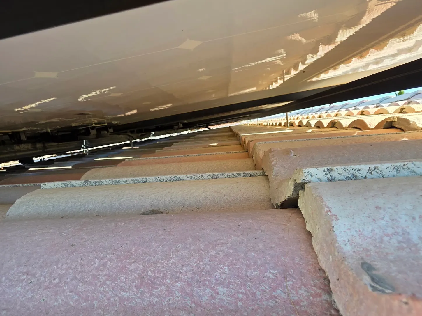 Job photo: looking into the shaded gap under solar panels on a Cathedral City tile roof, with no critter guard fitted
