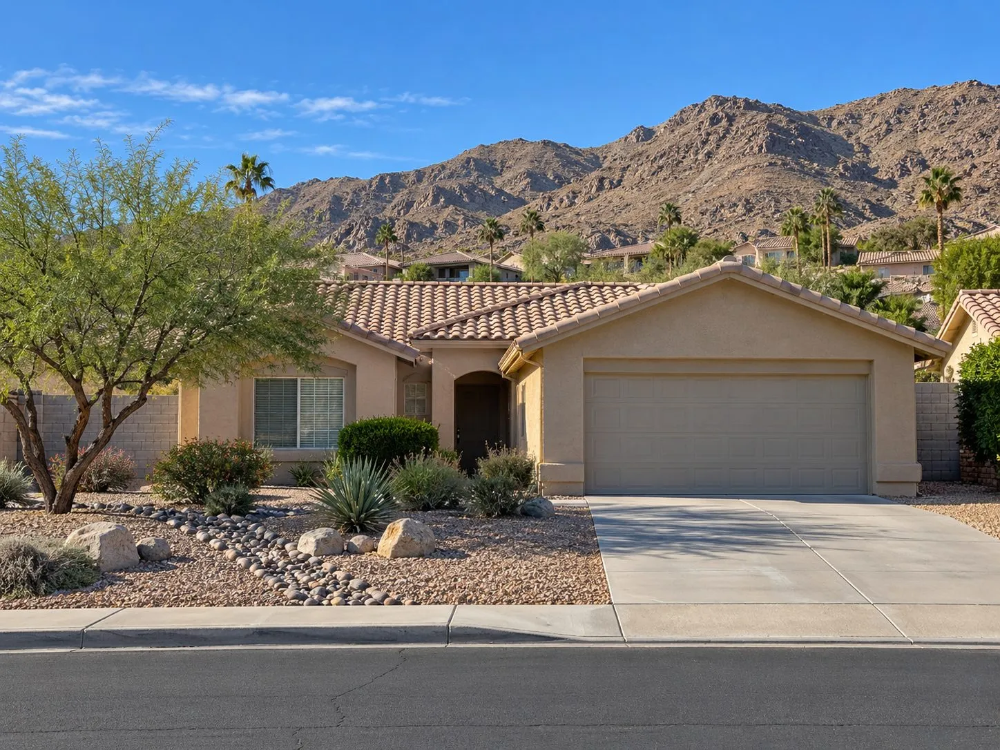 Property illustration: a tidy stucco ranch home against rocky foothills in the Cathedral City Cove