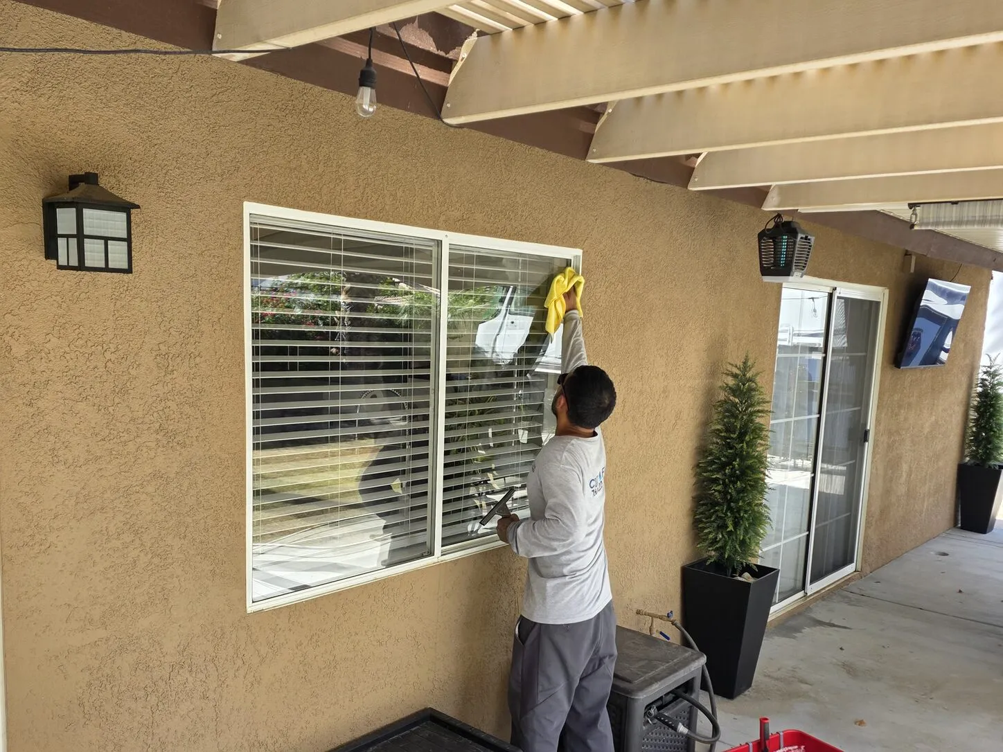 Job photo: a Clear Flow technician cleaning a patio window in Cathedral City