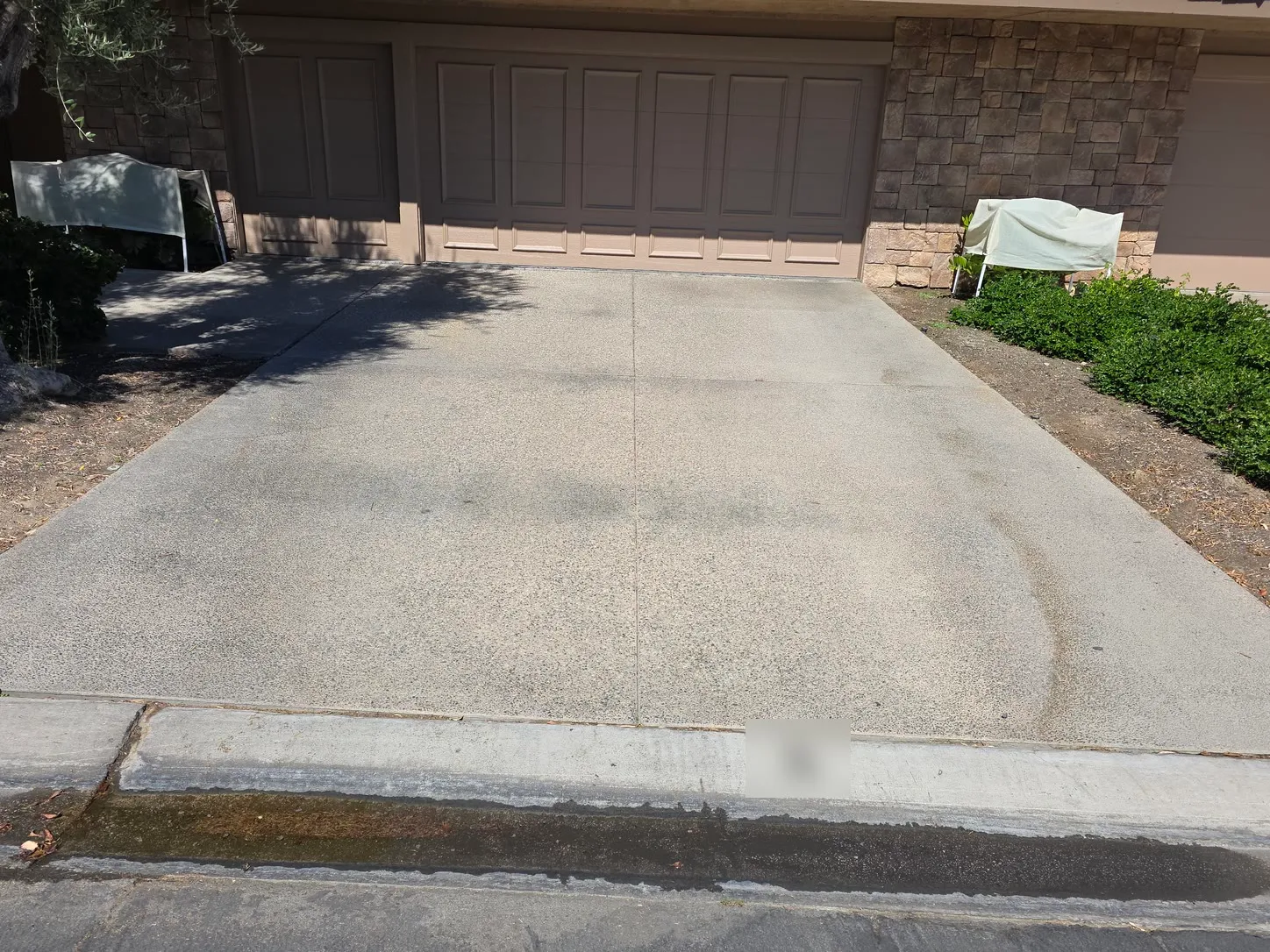 Job photo: a Rancho Mirage driveway on a pressure-washing job, with rinse water running along the curb