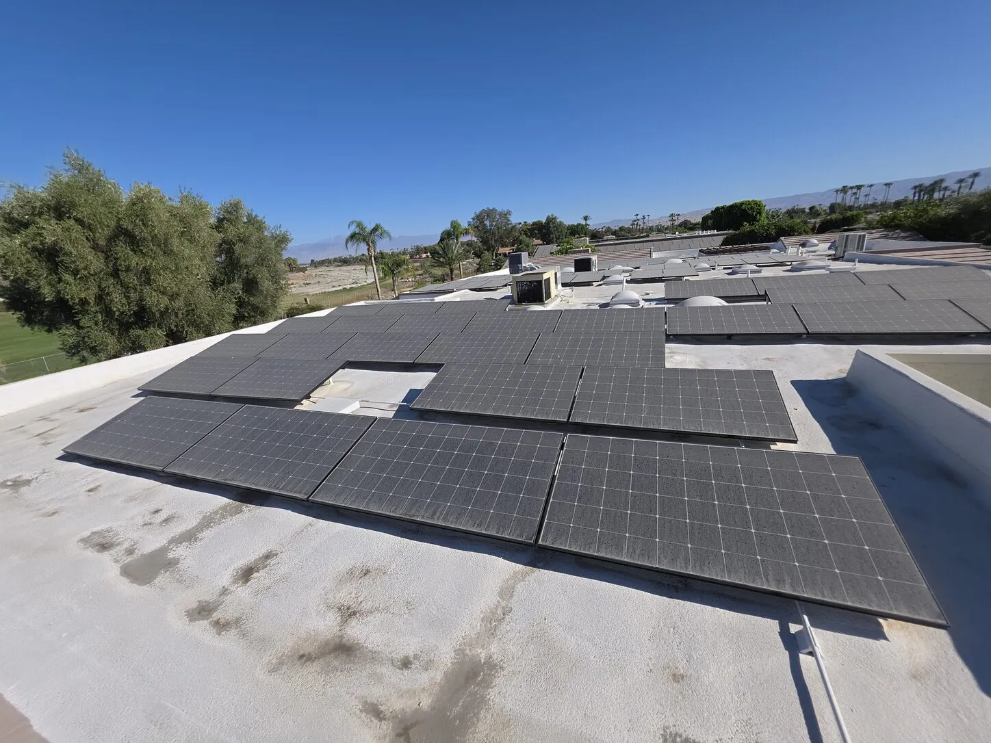 Job photo: a dusty solar array across a Rancho Mirage flat roof