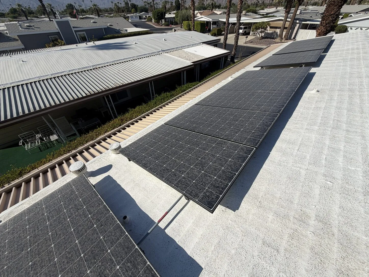 Job photo: dust-covered solar panels on a Palm Desert flat roof, before cleaning