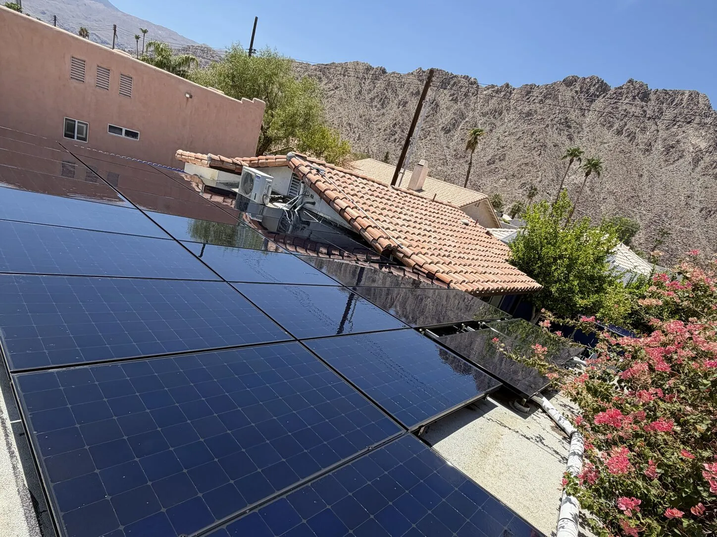 Job photo: a freshly cleaned solar array on a La Quinta flat roof below the mountains