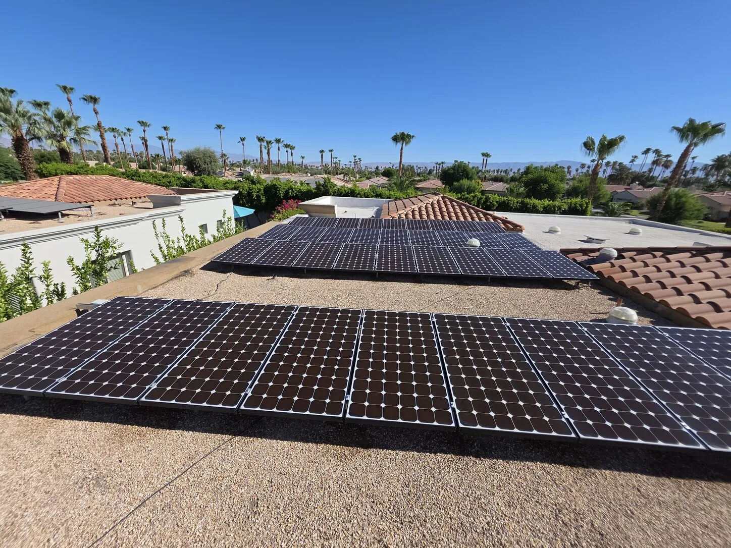 Job photo: two dusty solar rows on a Rancho Mirage flat roof, and the same rows after cleaning