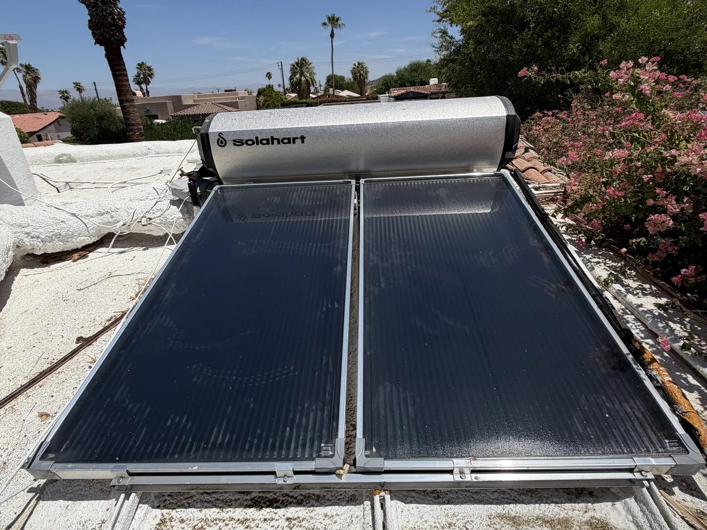 Job photo: a dust-covered rooftop solar water heater in La Quinta, and the same panels after cleaning