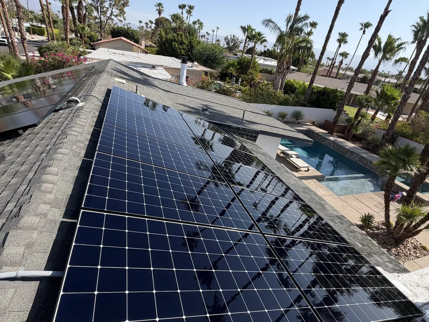 Job photo: a cleaned solar array on a Palm Springs shingle roof above a backyard pool